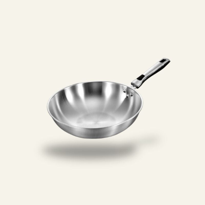 Le Shiomi wok 30 cm i blankt rustfrit stål med langt skaft, set skråt ovenfra mod en lys baggrund