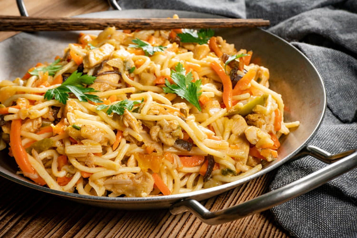 Chow mein med kylling, pak choi og nudler i en wok