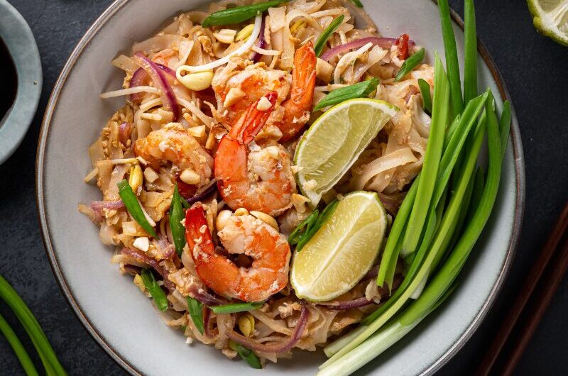 Pad thai med rejer, bønnespirer og peanuts i en wok