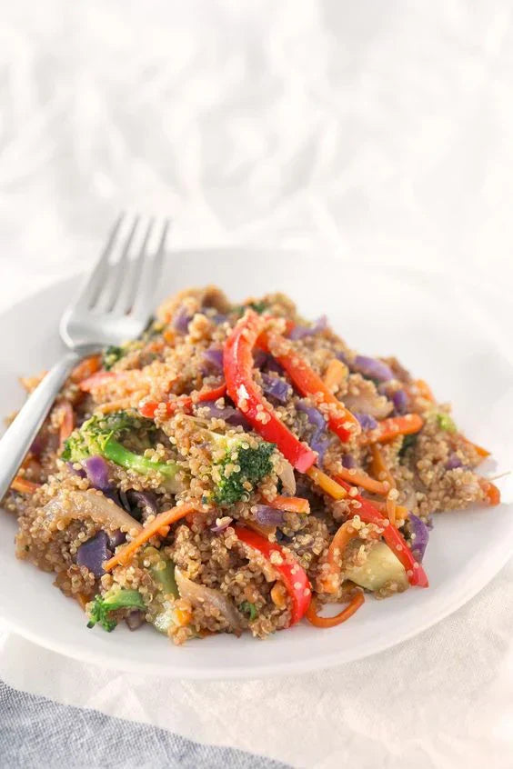 Vegansk Sichuan-wokret med peberfrugt, squash, bønnespirer og kinakål i en wok
