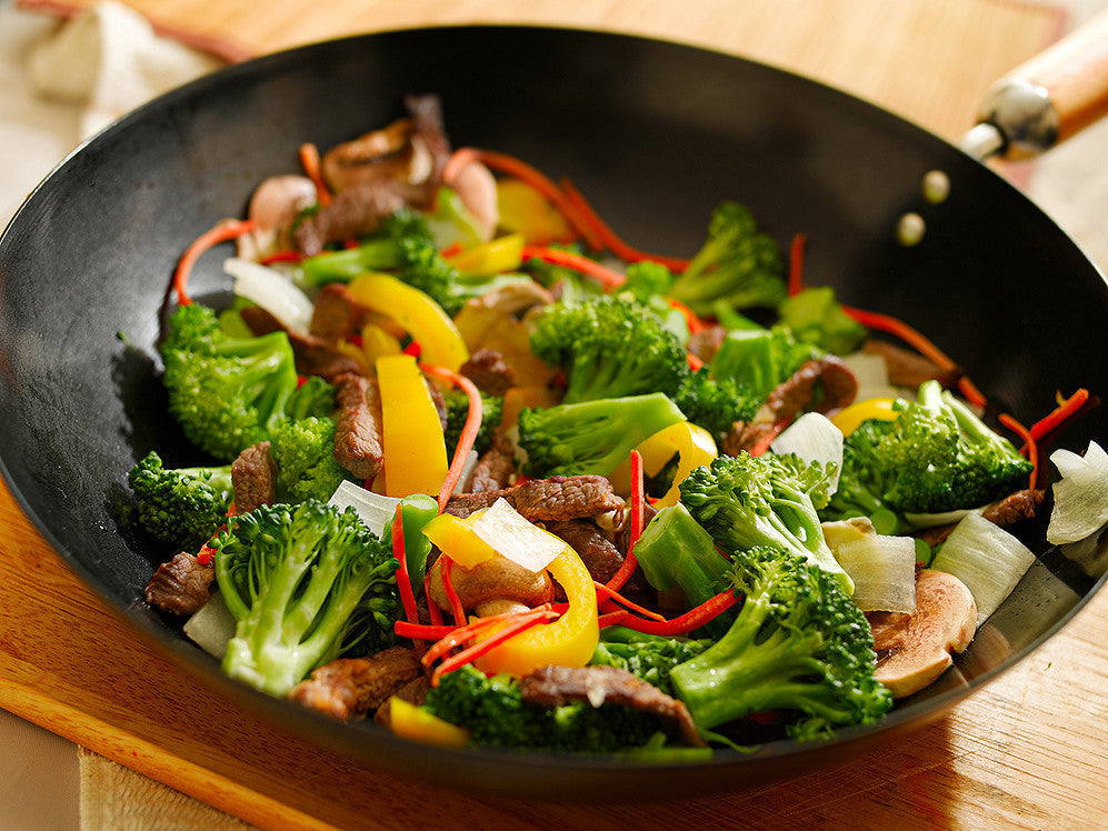 Vegansk broccoli-wok med ristede cashewnødder og sesamfrø i en wok