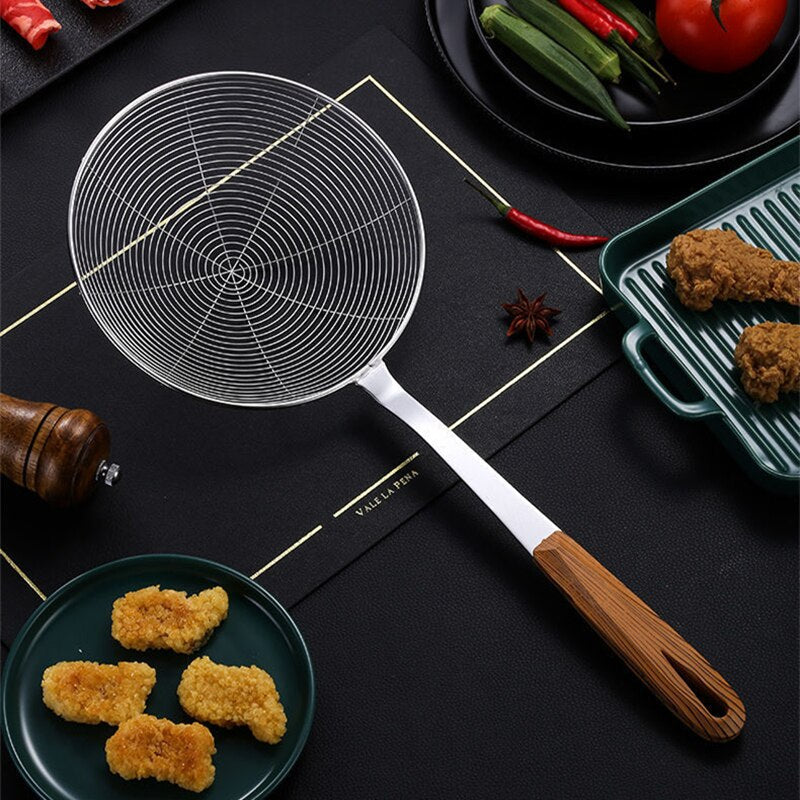 Hulske med trådkurv på et mørkt bord ved siden af friterede kyllingestykker, chili og grøntsager