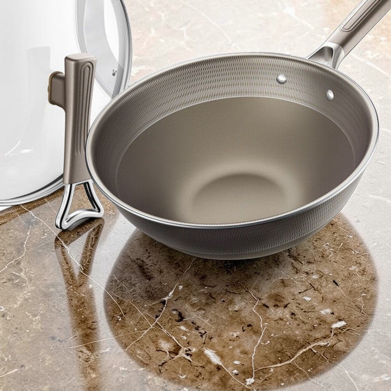 Wokken uden låg på marmorbordet, mens glaslåget står på højkant ved siden af