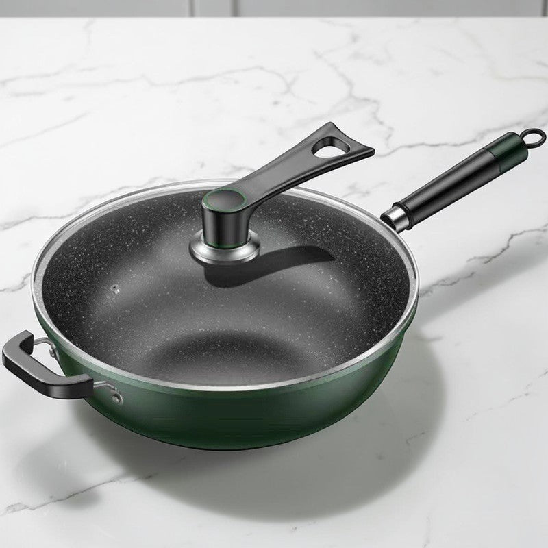 Grøn wok med glaslåget på, stillet på en hvid marmorbordplade