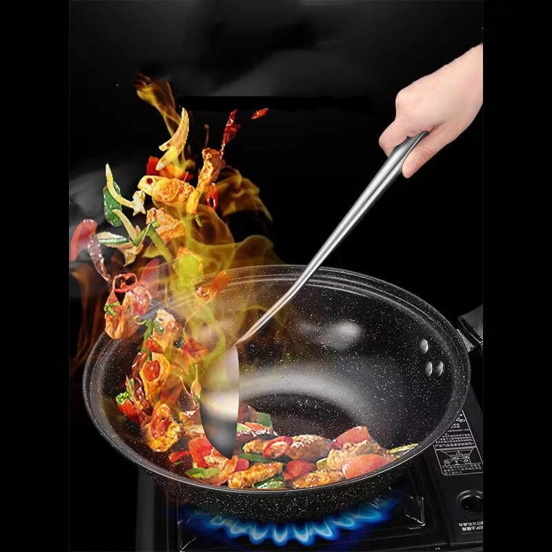 Hånd der rører i stegte grøntsager i en wok over et gasblus med et langt redskab i rustfrit stål