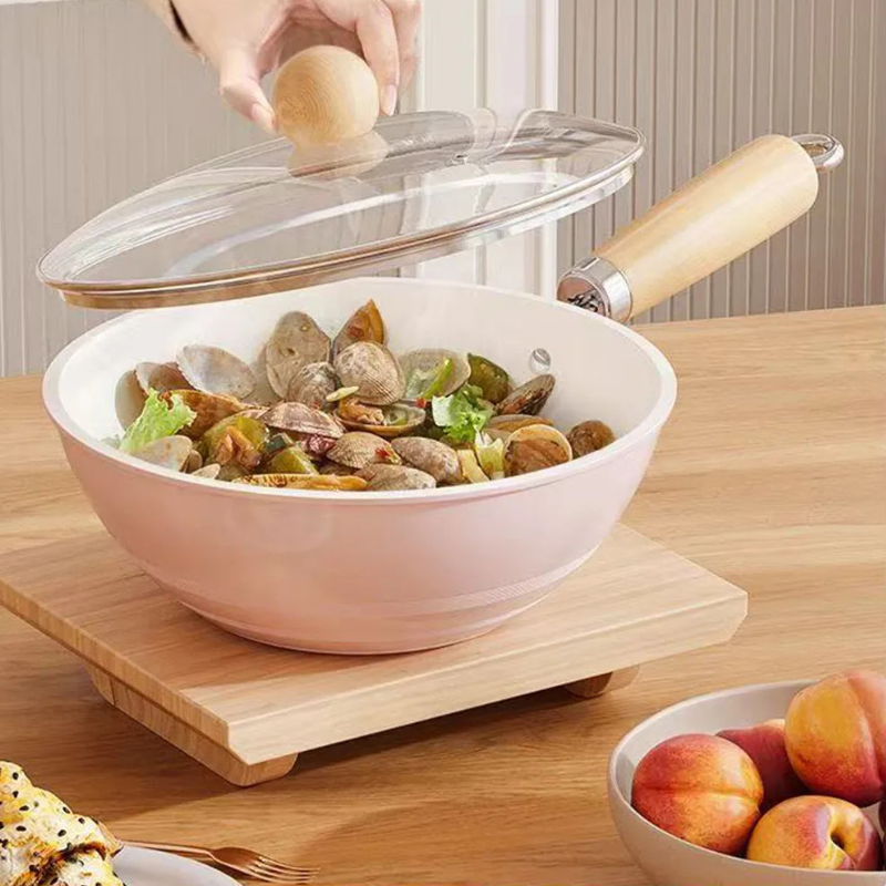 En hånd løfter glaslåget af en lys wok med muslinger og salat, stillet på et træbræt