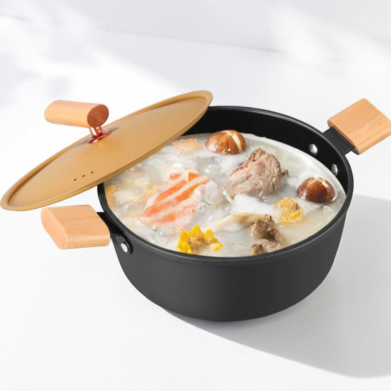 Gryden fyldt med suppe med kød, svampe og majs, set skråt fra siden