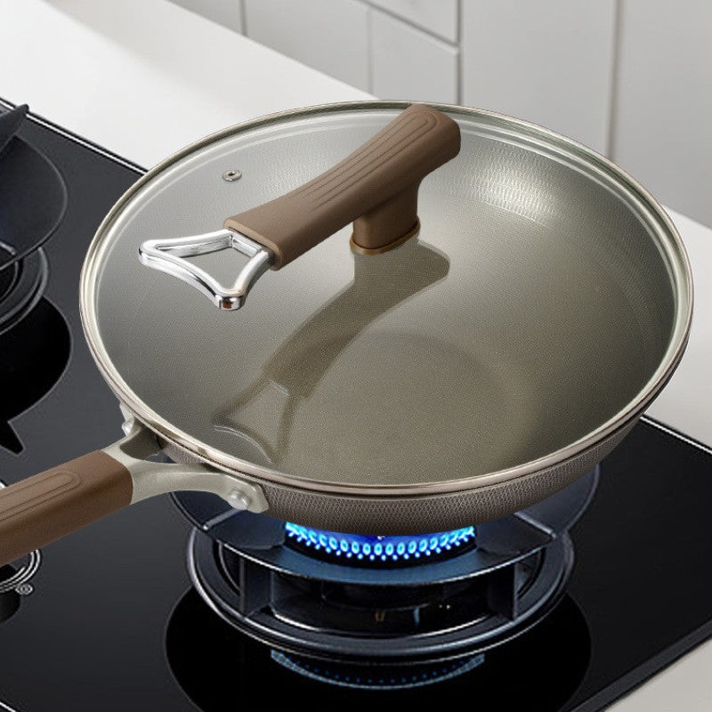 Wokpande med glaslåg på et gasblus med blå flamme på et sort komfur