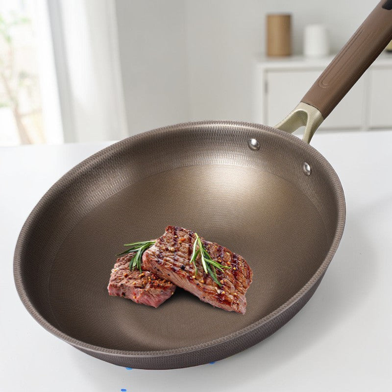 Grillet kød med rosmarin i panden på et lyst køkkenbord