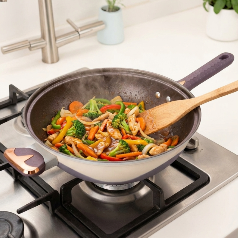 Kylling, gulerødder og broccoli steges i wokken på et gaskomfur, vendt med en træspatel