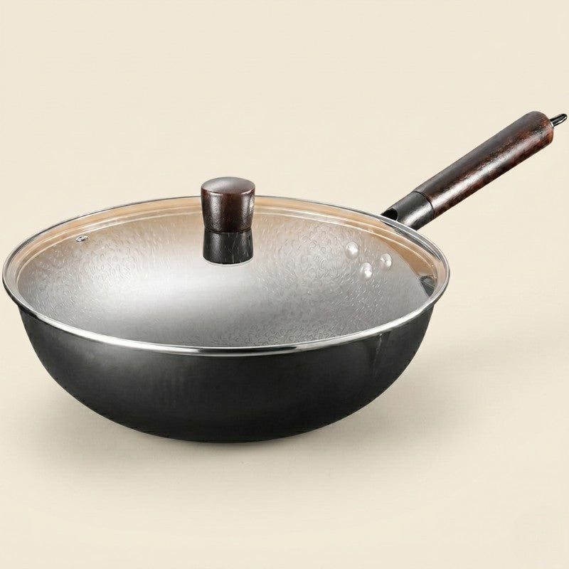 Le Haku kinesisk wok med glaslåg og træknop, set skråt fra siden på lys beige baggrund
