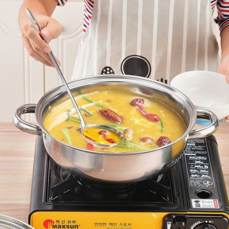 Underdelen brugt alene til en gul suppe med en øse, stillet på et lille gasblus