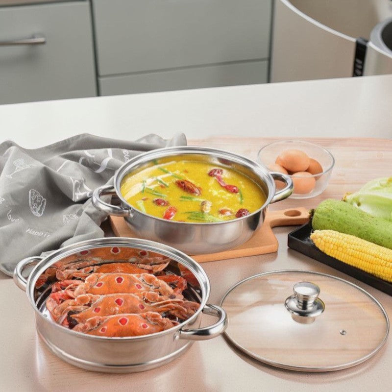 Dampindsats med krabber og underdel med suppe står hver for sig på bordet ved siden af glaslåget