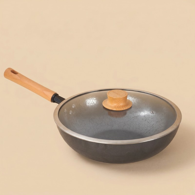 Le Kuroha wok i carbonstål med glaslåg, træknop og træskaft, fotograferet på en beige baggrund