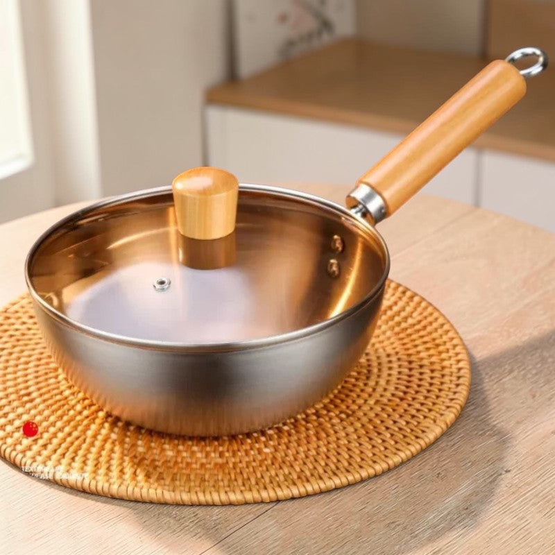 Wok med glaslåg på en rund flettet bordskåner