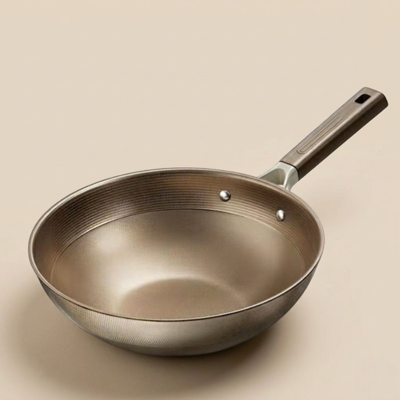 Wokken uden låg på beige baggrund, med mønstret overflade, to nitter og langt håndtag