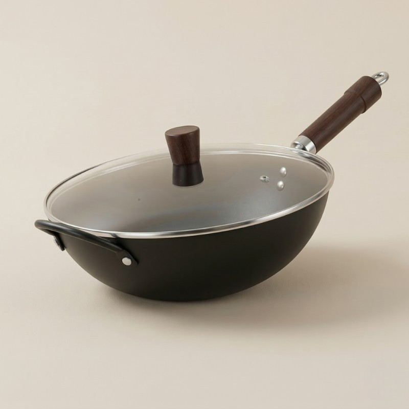 Le Ikari carbon stål wok med glaslåg, træhåndtag og sidehank, fotograferet på en lys beige baggrund