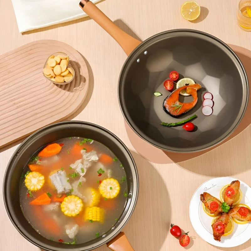 Set oppefra: to gryder, den ene med suppe med majs og gulerod, den anden med laks og cherrytomater