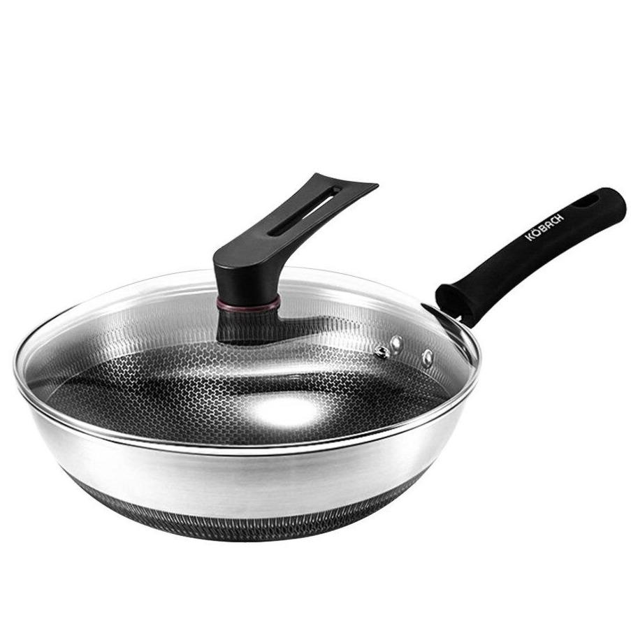 Wok i rustfrit stål med glaslåget på og bikubemønstret synligt gennem glasset, hvid baggrund