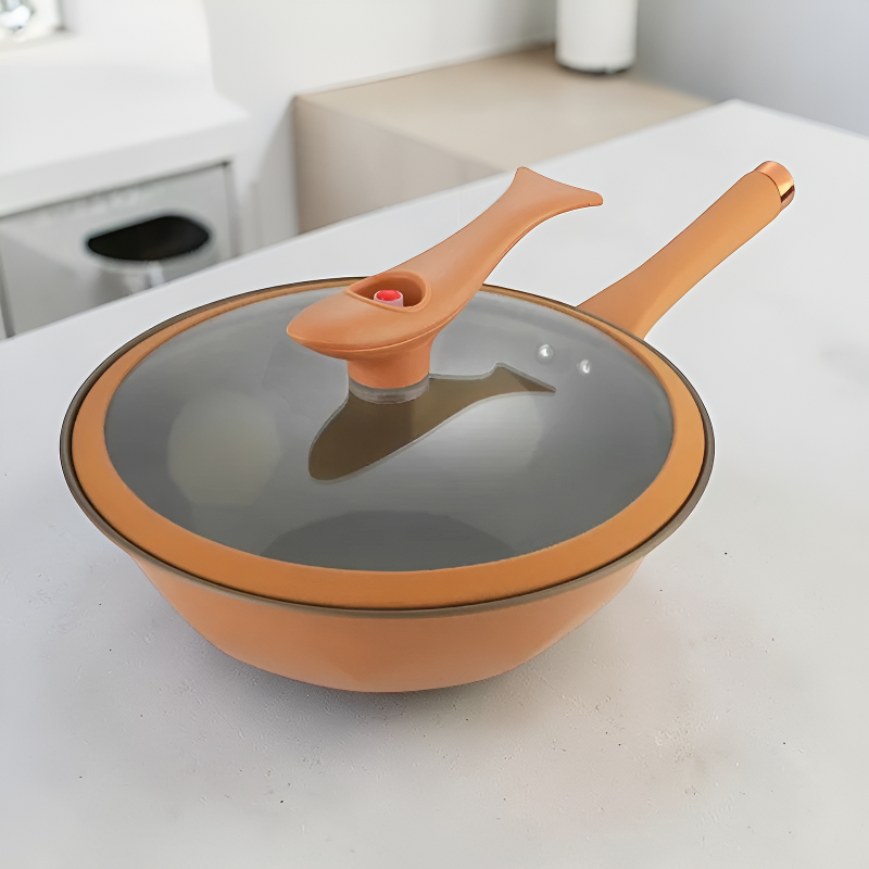 Den orange wokgryde med låget på, stillet på et hvidt køkkenbord