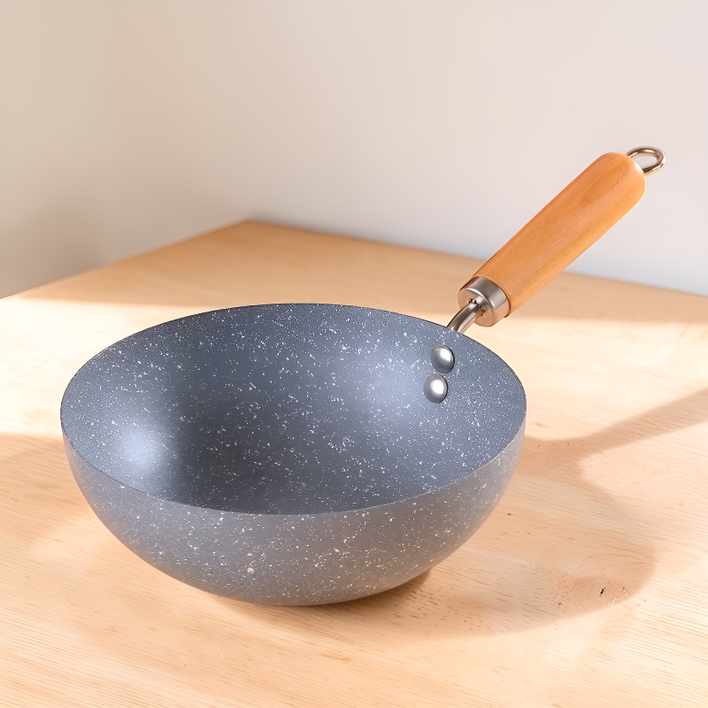 Grå mini wok uden låg står på et bord af lyst træ i dagslys
