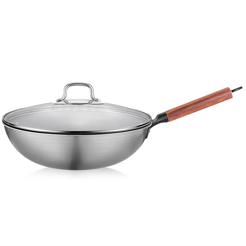 Wok i rustfrit stål med glaslåg og træskaft, set fra siden på hvid baggrund