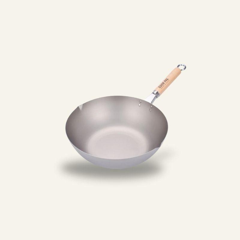 Le Meakan wok i rustfrit stål med træskaft og ophængsring, set skråt fra oven på lys baggrund