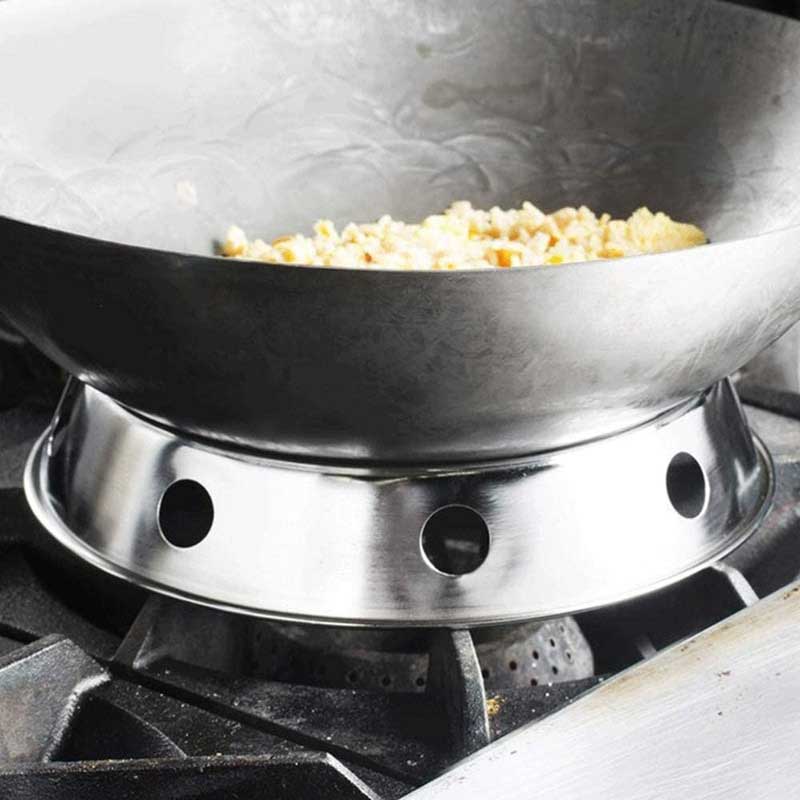 Nærbillede af en wok med stegte ris, der hviler i ringen over gasristen