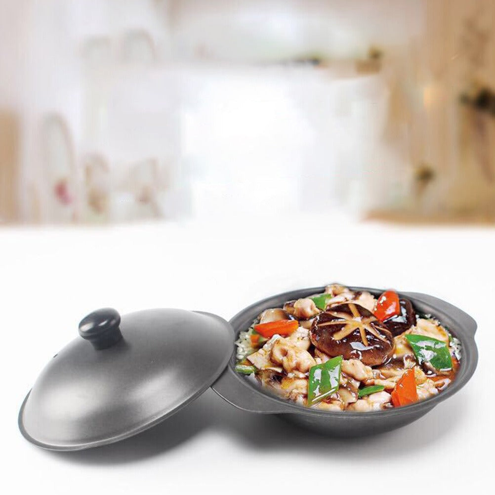 Wokpanden fyldt med kylling, svampe og grøntsager, med låget stillet ved siden af på et hvidt bord